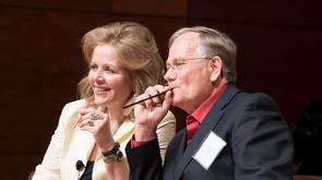 Renee Fleming and Ingo Titze sitting together at a session at PAVA conference in 2015. Dr. Titze is holding a small straw in his moutn demonstrating SOVT exercises.